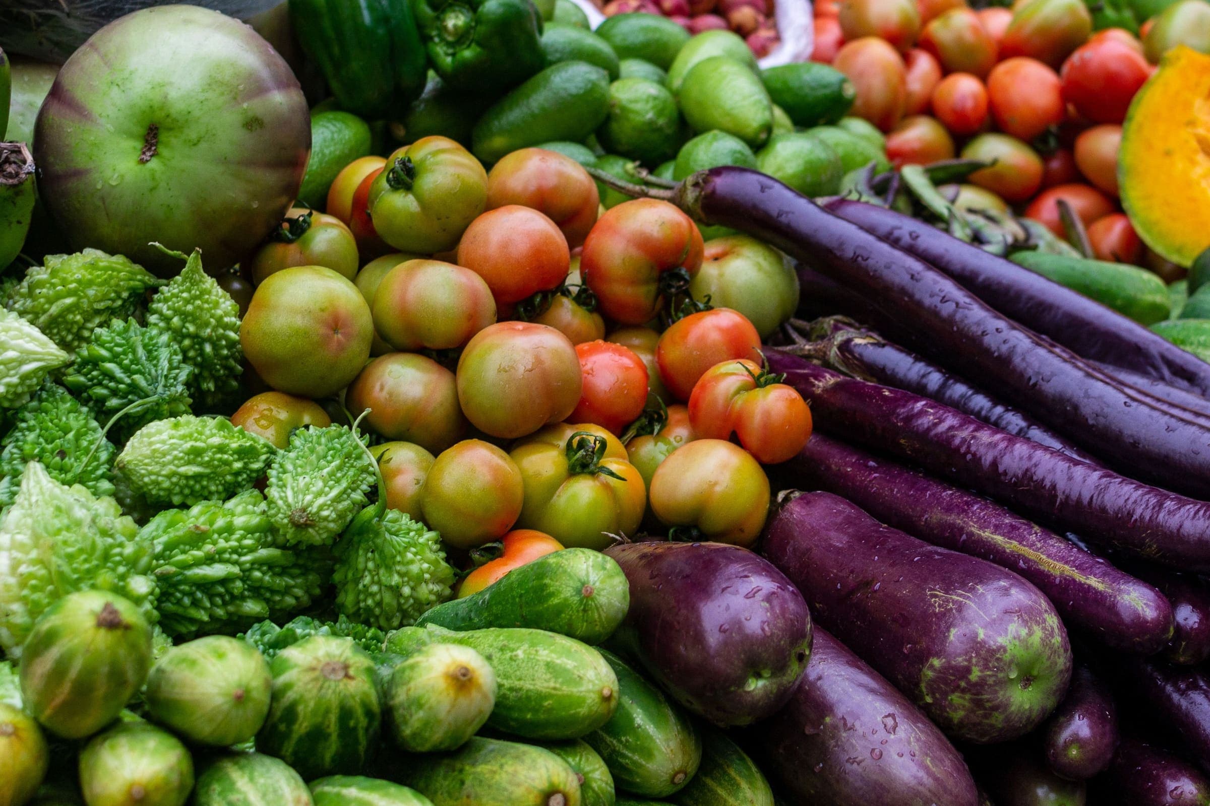 Fresh vegetables piled high at a busy Dhaka market